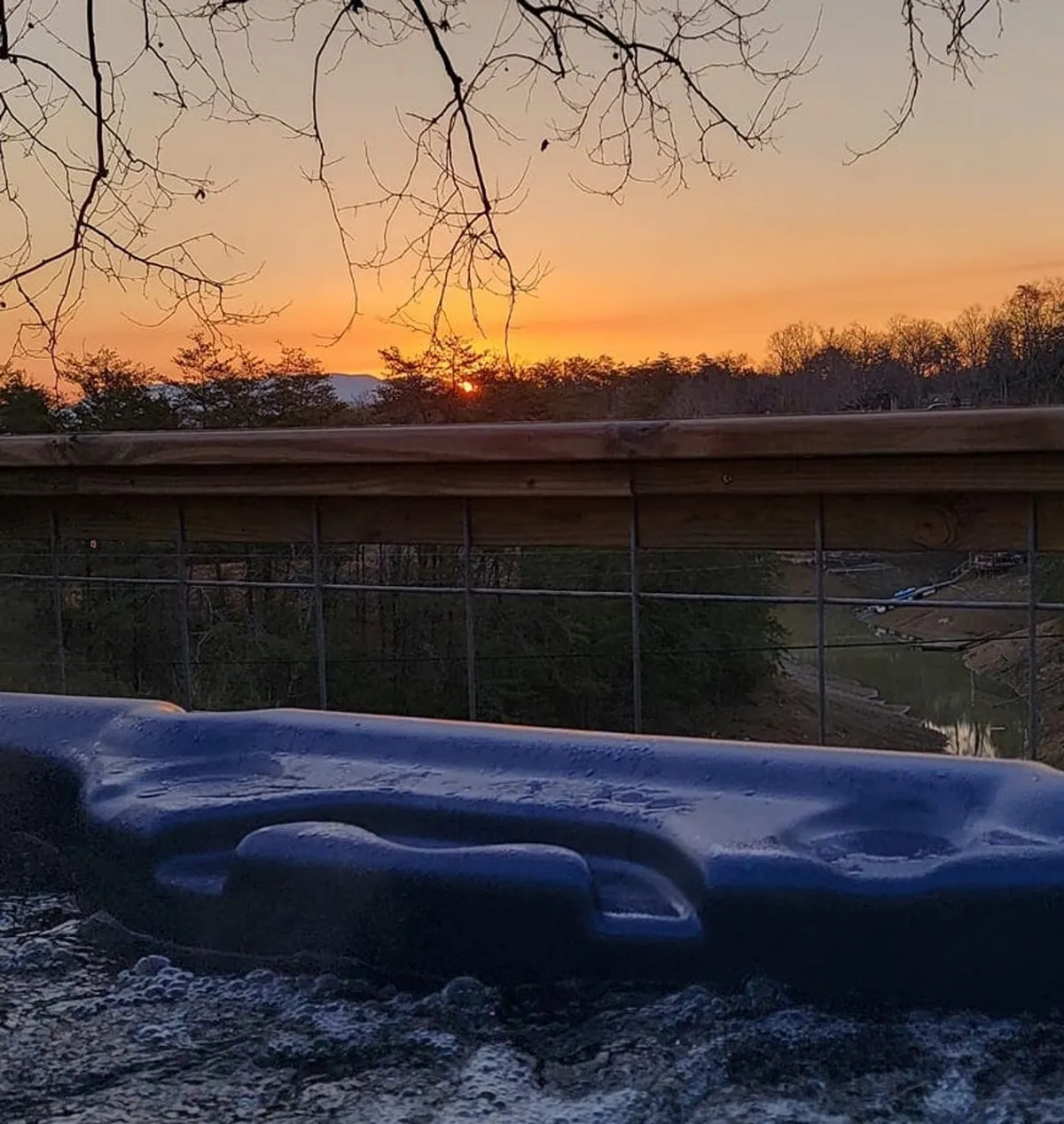 A tranquil view of a sunset over the horizon as seen from the edge of a spa or hot tub. The peaceful ambiance invites relaxation and features the natural beauty surrounding the property—perfect for unwinding after a day of exploration.
